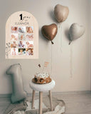 Close-up of custom baby name and top row of monthly milestone pictures on wooden 1st birthday photo sign.